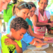 Children making tortillas with woman